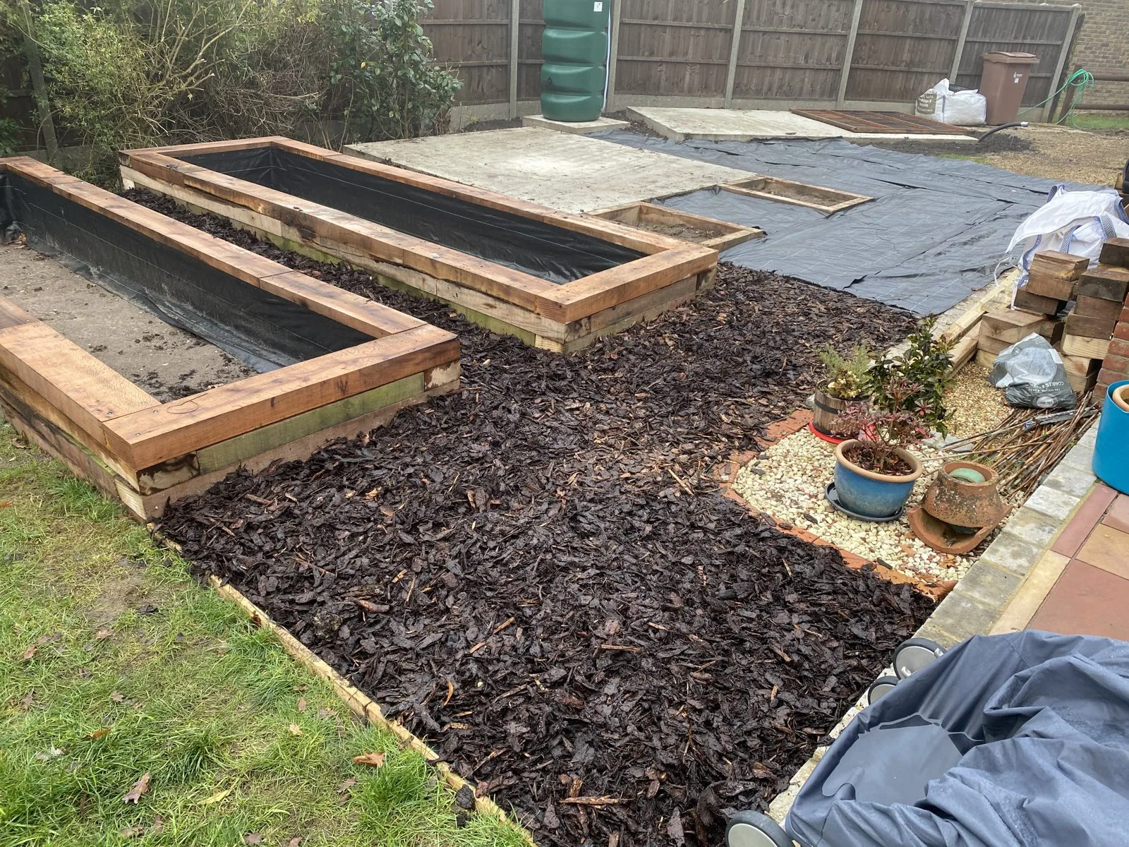 New timber sleeper raised beds with black lining and surrounding bark mulch