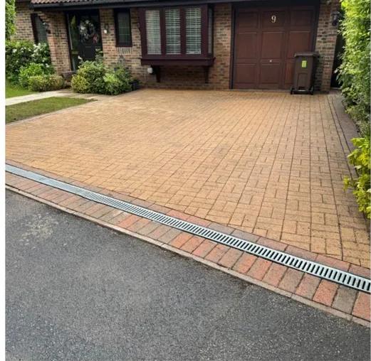 The same block-paved driveway cleaned back to bare paving after jet washing